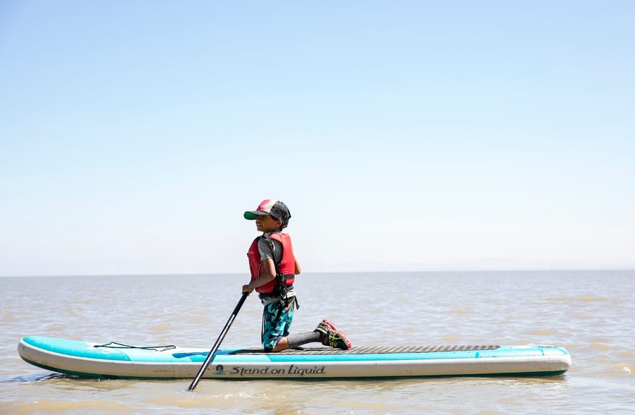 young kid stand up paddleboarding in the Bay Area of California