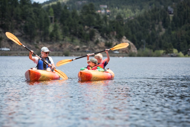 summer camp counselor teaching kayaking to campers