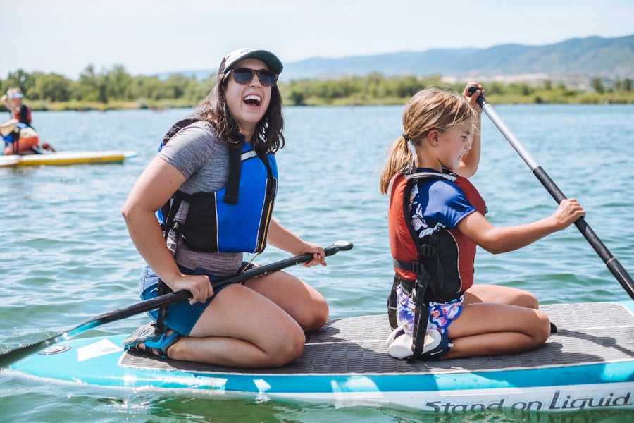 camp counselor teaching stand up paddleboarding