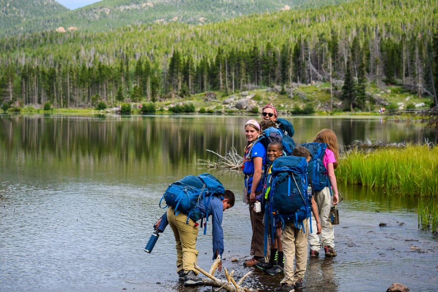 kids backpacking near a mountain lake